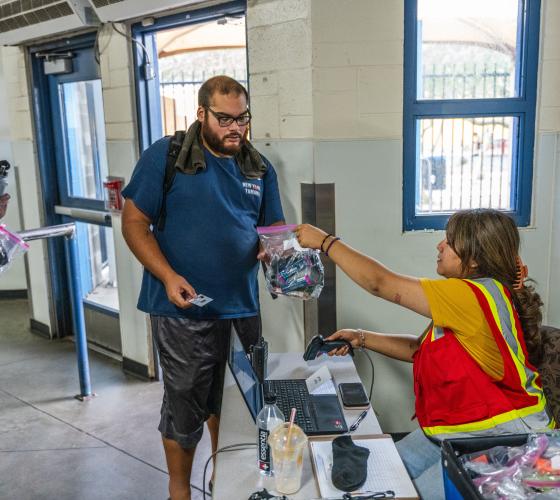volunteer handing a man a hygiene kit during daytime heat relief