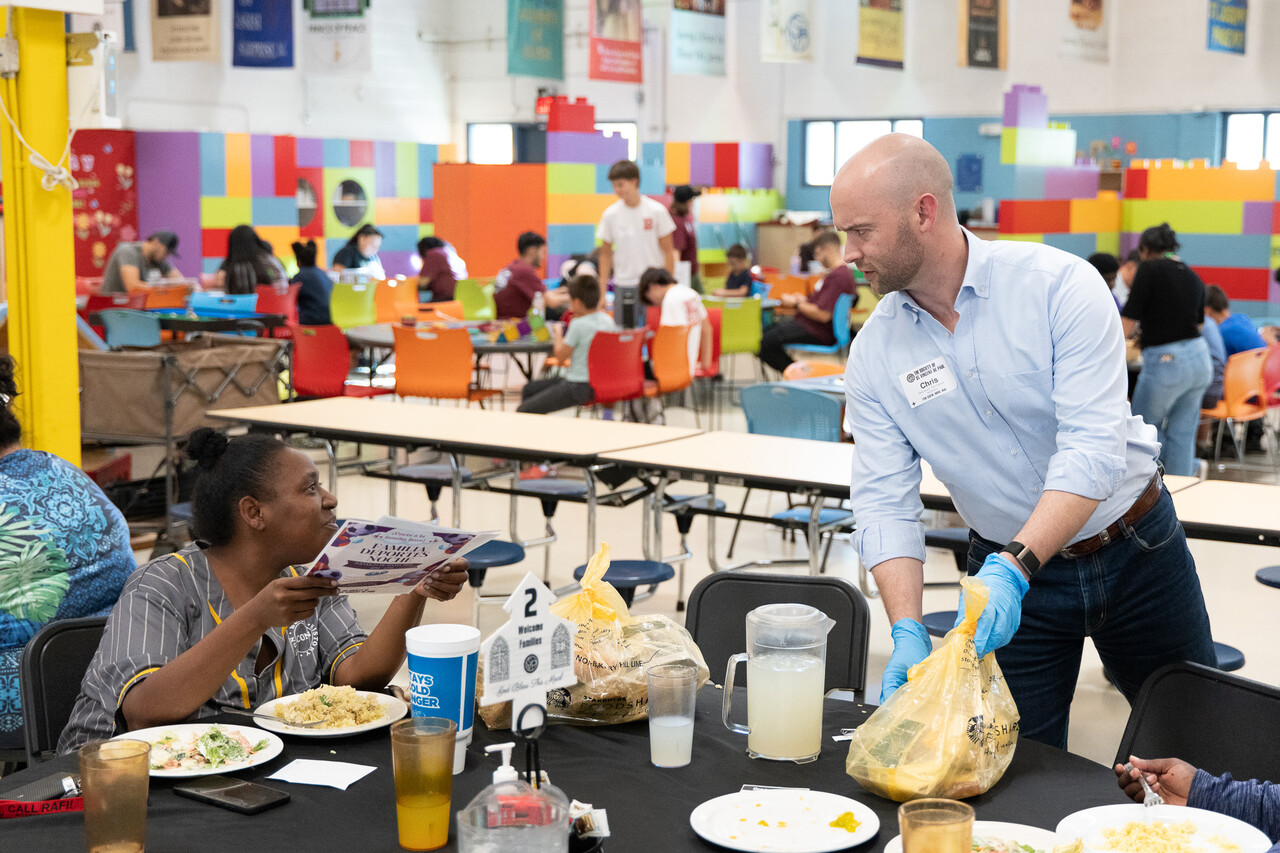 Chris Cottrell hands out food to guests at Family Evening Meal.