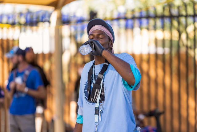 A man drinking from a bottle of water outside.